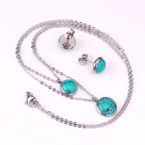 Detalle macro de conjunto de collar con colgante de turquesa y pendientes en acero plata