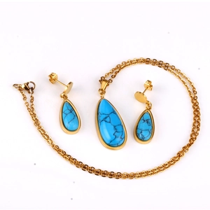 Detalle del conjunto de joyas turquesa con colgantes de gota y acabado dorado