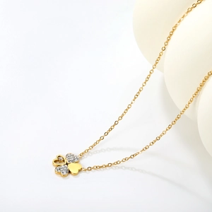 Elegant gold four-leaf clover necklace with sparkling white zircons and heart details