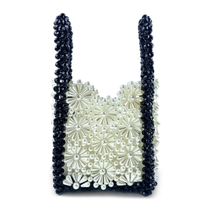 Close-up of handmade daisy pearl beaded handbag with contrasting black bead trim
