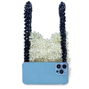 Detail of white daisy pearl beaded handbag with black handle and smartphone for size scale