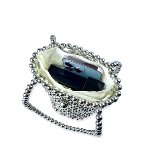 Top view of silver beaded handbag showing white drawstring pouch and interior capacity