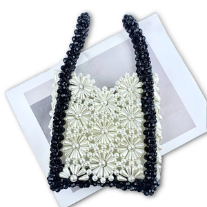 Macro shot of handmade floral pearl bead handbag with black and white daisy pattern