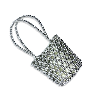 Detail of silver beaded handbag showing intricate sphere mesh and metallic texture
