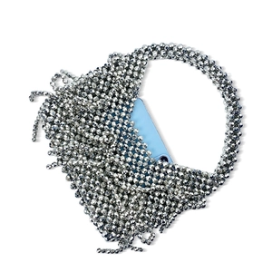 Détail d'un sac à main argenté avec perles et franges montrant la capacité intérieure