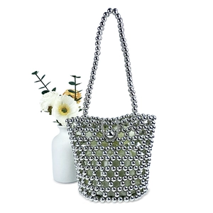 Detail of silver beaded bucket bag featuring handmade woven texture and silk lining
