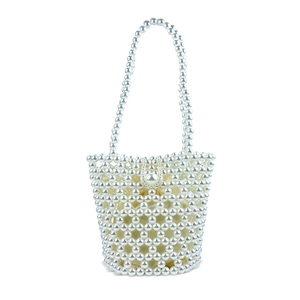 Close-up of handmade pearl woven bucket bag with elegant satin drawstring inner pouch
