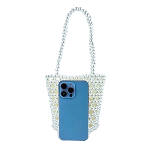 Mini pearl beaded bucket bag detail shown next to a smartphone for size comparison