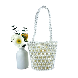 Detail of handmade white pearl woven handbag with elegant beaded strap and satin lining