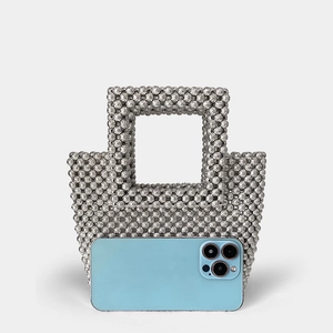 Detail of silver beaded handbag showing internal capacity with a smartphone inside