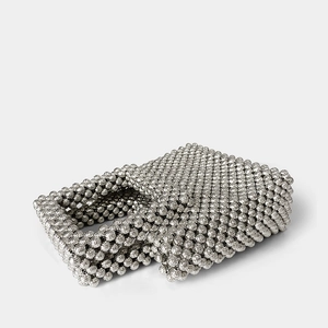 Macro detail of silver acrylic beaded handbag showing intricate woven texture and metallic finish