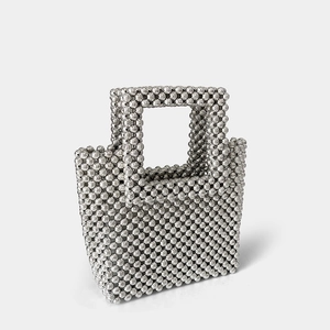 Close-up of handmade acrylic beaded square handbag with silver metallic finish and woven handle