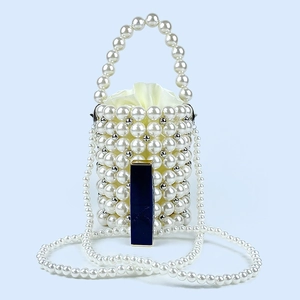 Detail of beaded pearl bucket bag with silver accents and yellow satin drawstring liner