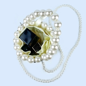 Detail of beaded pearl bucket bag showing satin drawstring pouch and interior capacity