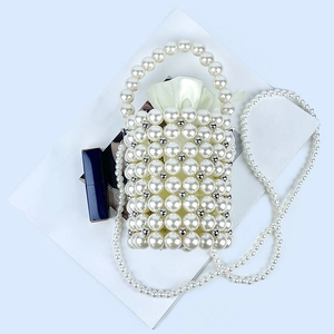 Detail of hand-woven pearl bucket bag with satin drawstring lining and round handle