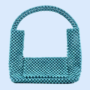 Detail of handmade turquoise beaded handbag featuring intricate woven resin beads