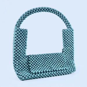 Detail view of turquoise marbled beads on a handmade U-shaped woven handbag strap