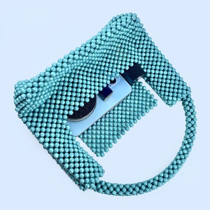 Detail of turquoise handmade beaded handbag with U-shape flap and smooth bead texture