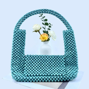 Detail of turquoise beaded handmade handbag with round beads and woven texture