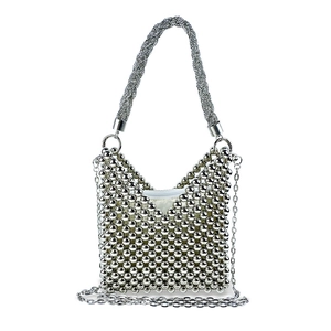 Detailed view of silver beaded handbag with woven handle and metallic chain strap