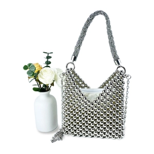 Detail of silver beaded handbag showing intricate hand-woven texture and zipper closure