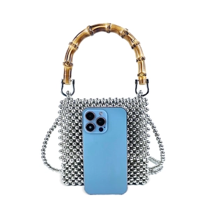 Mini silver beaded bag with bamboo handle shown next to a smartphone for size reference