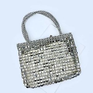 Close-up of silver metal sequin woven handbag showing detailed metallic grid craftsmanship