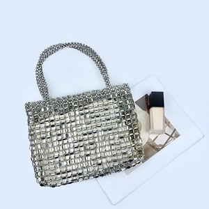 Detail of silver beaded handbag showing intricate metal mesh and minimalist woven structure