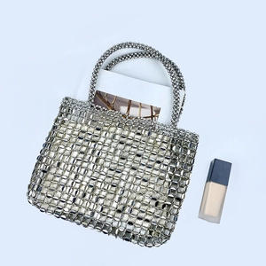 Close-up of silver beaded mesh tote bag featuring intricate metallic coin-style handcrafting