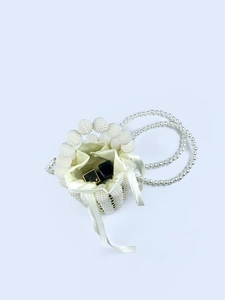 Detail view of pearl beaded bucket bag showing silk drawstring closure and interior space