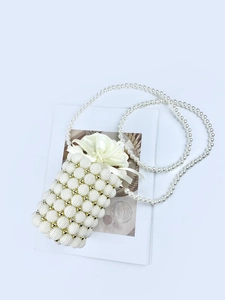Detail view of woven pearl evening bag featuring gold beads and satin drawstring closure