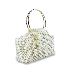 Detail of beaded evening bag with white faux pearls and gold circular metal handle