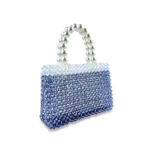Detail of a handmade beaded handbag with purple gradient beads and a faux pearl handle