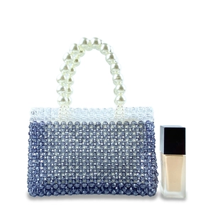 Detail of handcrafted beaded handbag with navy blue gradient and pearl handle texture