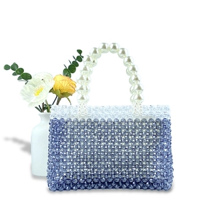 Detail of handmade beaded handbag with gradient blue beads and a faux pearl handle