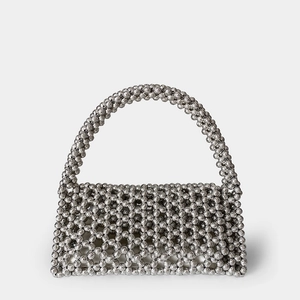 Detail of silver beaded handbag featuring handmade woven metallic beads and round handle