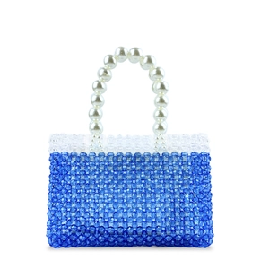 Detailed view of deep blue beaded handbag with luxury white pearl top handle