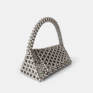 Macro detail of silver triangular handmade woven beaded handbag with metallic texture