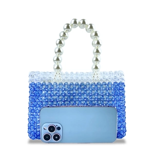 Detail of handmade beaded handbag with blue gradient beads and pearl top handle