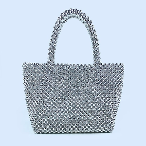 Detailed close-up of a silver beaded evening bag featuring intricate hand-woven craftsmanship