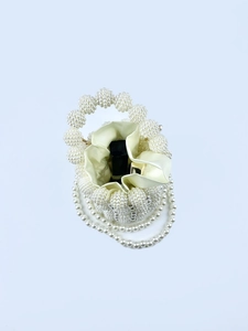 Detailed top view of handmade pearl bucket bag with satin lining and drawstring closure