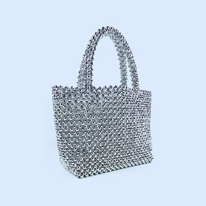 Detail of silver beaded tote bag showing intricate shimmering woven texture and dual handles
