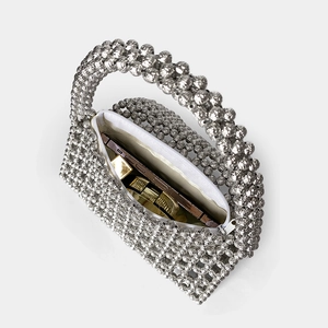 Detail of silver beaded handbag showing white fabric lining and interior zipper closure