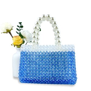 Detailed view of handmade gradient beaded handbag with elegant faux pearl handle on white base