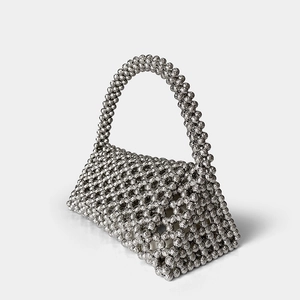Detail of silver handcrafted beaded handbag showing the geometric mesh and metallic luster