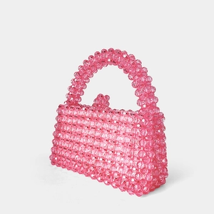 Détail d'un sac à main artisanal en perles de cristal rose avec perles acryliques