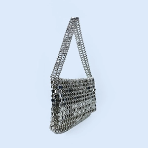 Macro detail of the silver sequin bag showing manual chainmail assembly and metal texture
