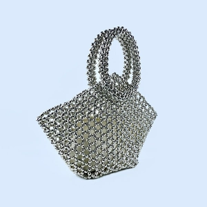Detail of silver beaded handbag with hollow mesh weave and cream drawstring liner