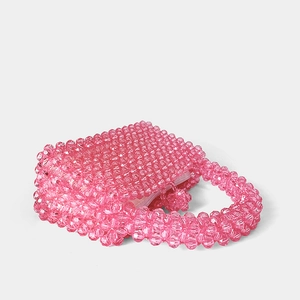 Détail du sac artisanal en perles acryliques roses avec une finition cristalline