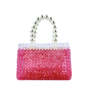 Macro shot of handmade beaded handbag with pink crystals and pearl handle detail